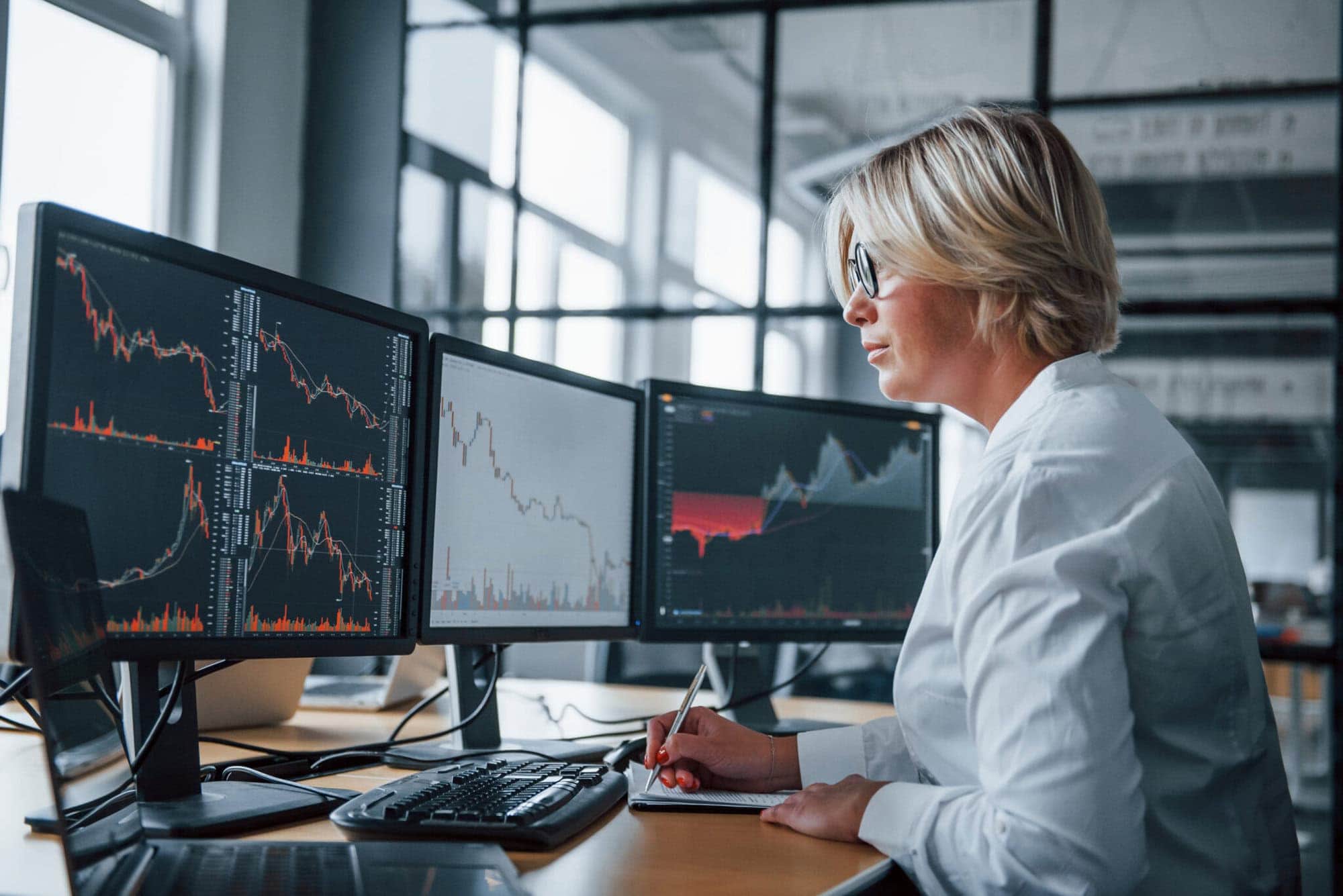 Female stockbroker in formal clothes works in the office with financial market.